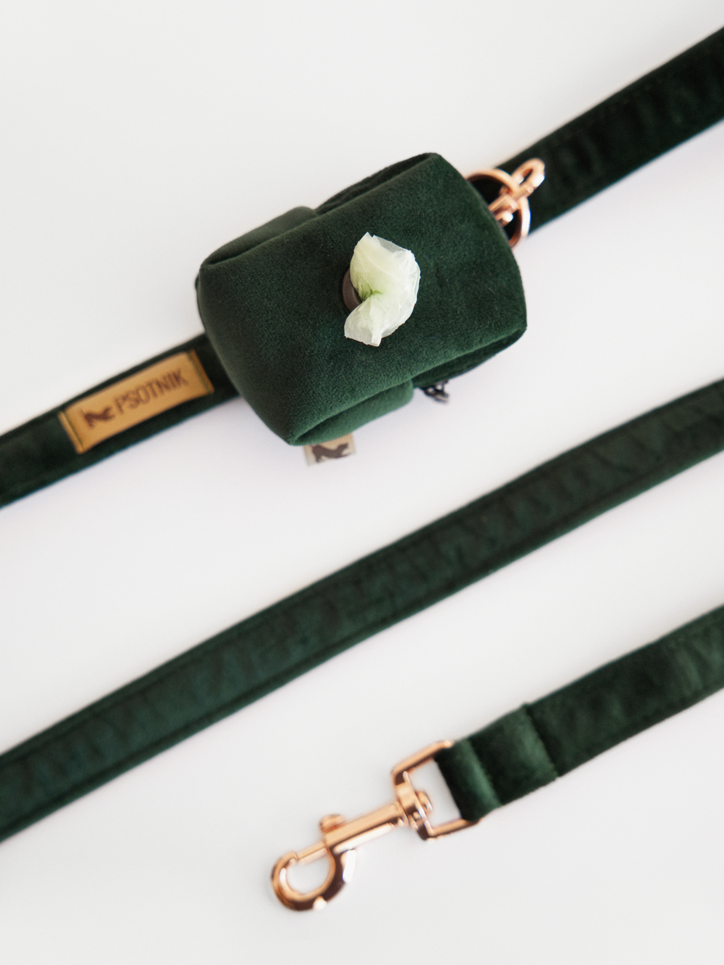 Welurowe etui na kupoworki w kolorze butelkowej zieleni założone na smycz