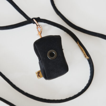 Etui na kupoworki w kolorze czerni przyczepione do smyczy