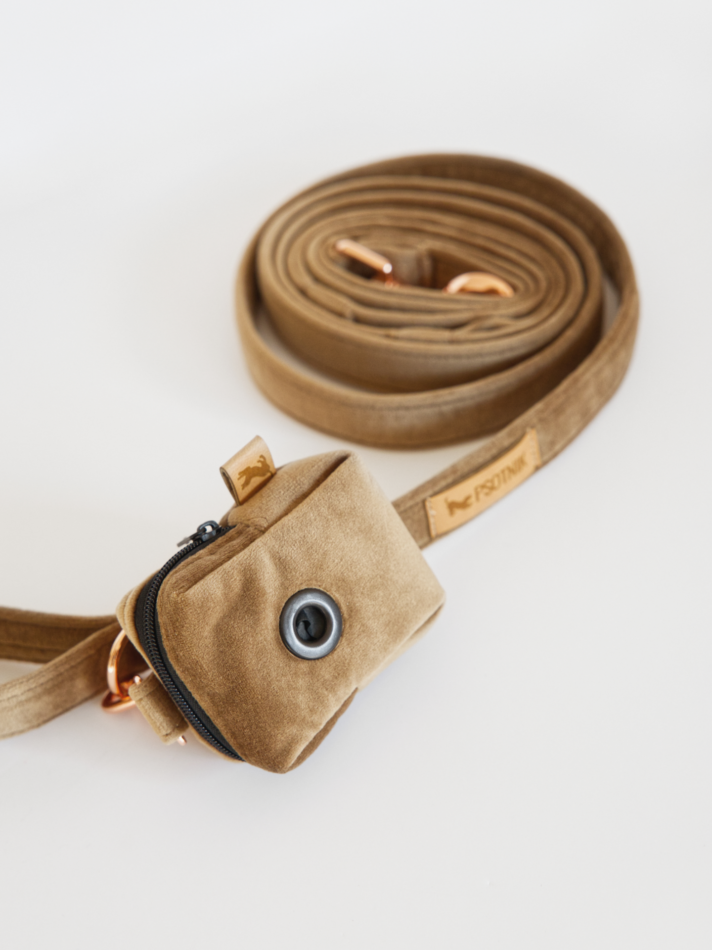 Brązowe welurowe etui na kupoworki przypięte do smyczy